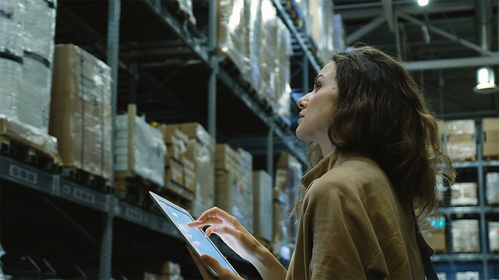 Female checking logs in a warehouse