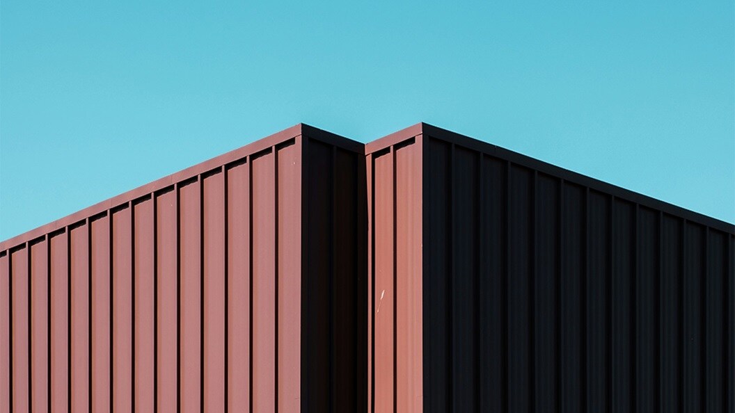 A dark red container silhouette against a light blue sky