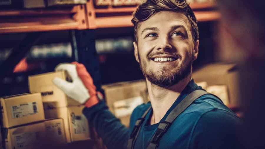 A man happily selects a box while glancing upward.