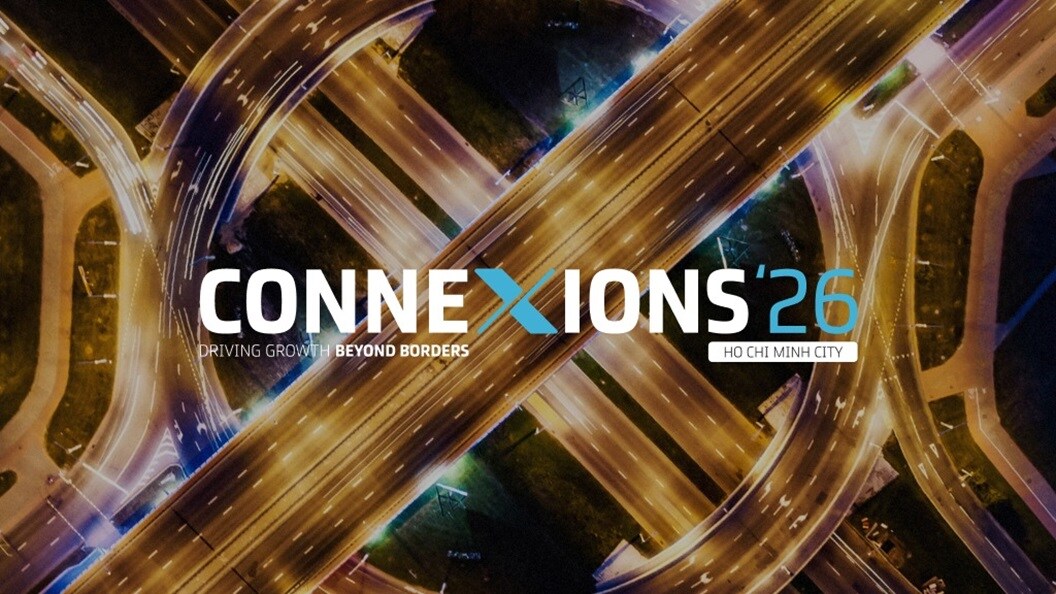 Aerial view of a highway intersection illuminated at night, showcasing the flow of traffic and surrounding city lights.