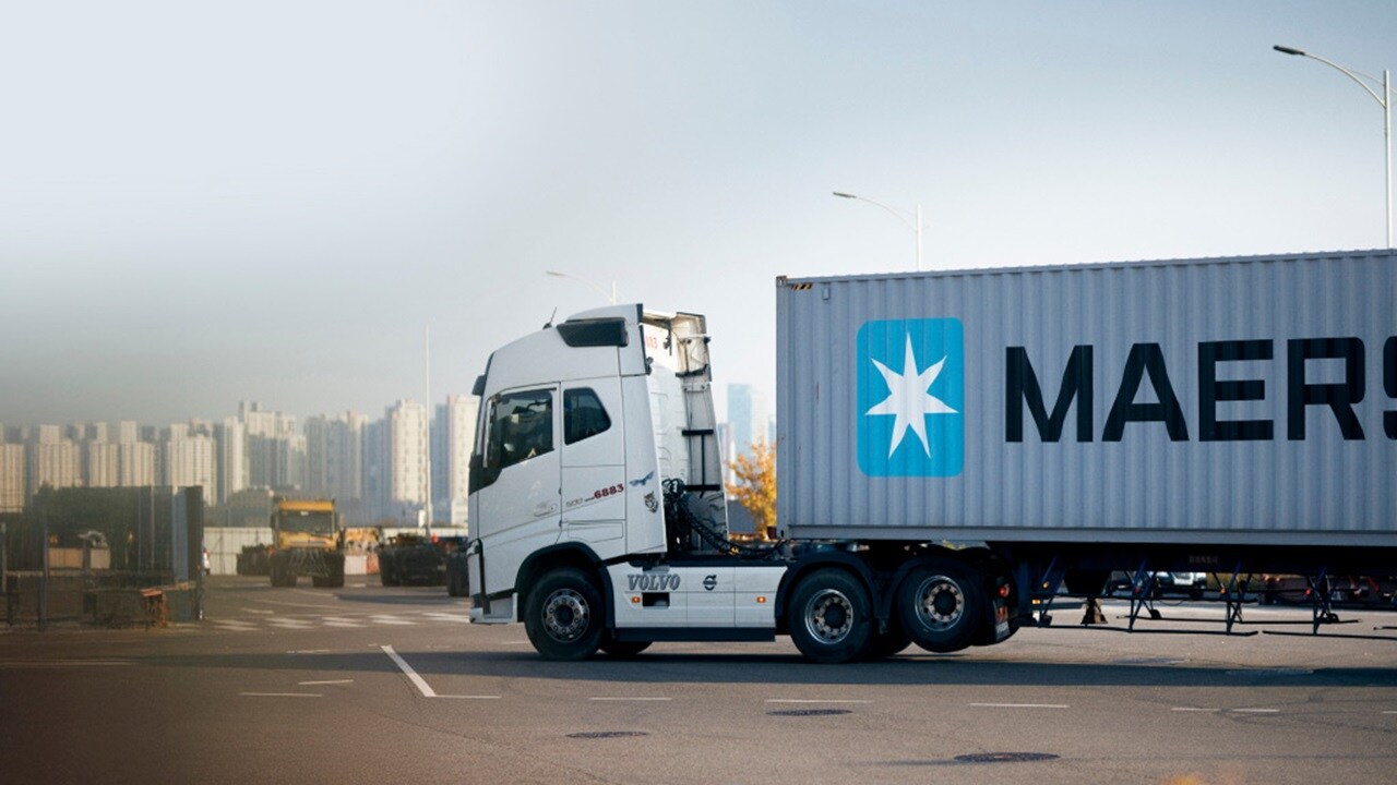 A large truck displaying the word "Maersk" prominently on its side, parked on a city street.