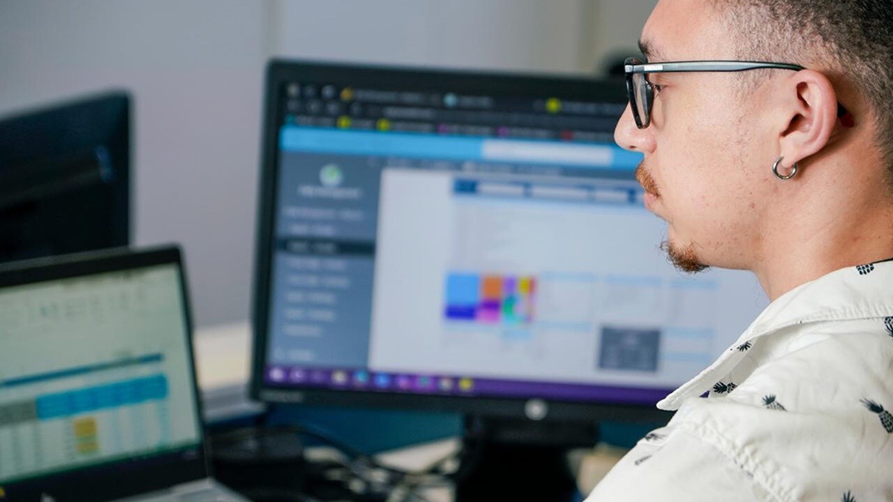 Maersk Customs Services employee sitting at a computer in a Maersk office.