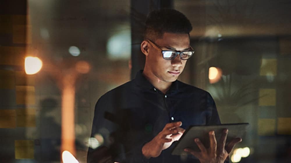 一位年轻男士使用平板电脑搜索 API 解决方案。