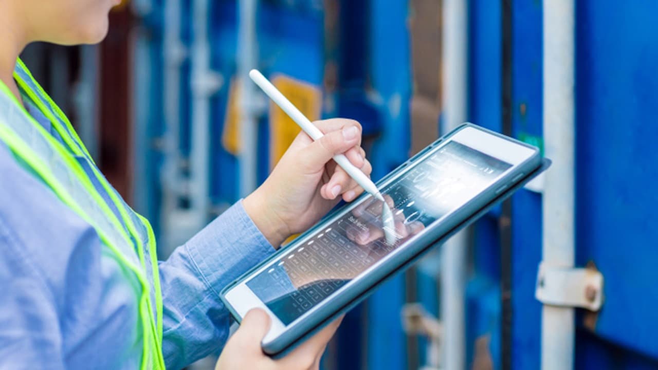 Person using digital tablet with stylus to analyze supply chain data for decision making