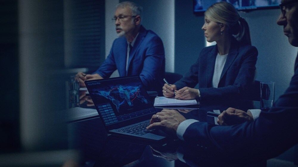 一群商务专业人士在光线昏暗的会议室中严肃讨论。